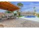 Outdoor patio with stylish seating, and a luxurious pool with mature palms at 4106 E Muirwood Dr, Phoenix, AZ 85048