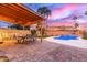 Beautiful backyard with a covered patio, a pool, and a lush green lawn at 4106 E Muirwood Dr, Phoenix, AZ 85048