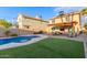 Inviting backyard with a sparkling pool, lush artificial grass, and a covered patio for outdoor entertaining at 4106 E Muirwood Dr, Phoenix, AZ 85048