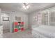 Airy bedroom featuring a daybed, ample storage, ceiling fan, and a window with striped curtains at 4106 E Muirwood Dr, Phoenix, AZ 85048