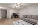Spacious living room with a large sectional, computer desk, and a ceiling fan, creating a functional area at 4106 E Muirwood Dr, Phoenix, AZ 85048