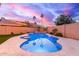 Sparkling pool with a baja shelf, lush landscaping, and string lights at 4106 E Muirwood Dr, Phoenix, AZ 85048