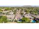 A stunning view from above of neighborhood with gorgeous pools, lush landscaping, and desert mountain views at 5226 S Fairchild Ln, Chandler, AZ 85249