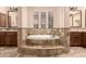 Elegant soaking tub with tiled surround, set between two vanities with mirrors and sconces at 5226 S Fairchild Ln, Chandler, AZ 85249