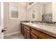 Bathroom with a granite countertop, wood cabinets, a decorative mirror, and shuttered windows at 5226 S Fairchild Ln, Chandler, AZ 85249