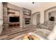 Spacious living room featuring a stone fireplace, built-in entertainment center, and hardwood floors at 5226 S Fairchild Ln, Chandler, AZ 85249