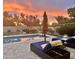 Inviting backyard pool with lounge chairs, umbrella, and a beautiful sunset view at 5226 S Fairchild Ln, Chandler, AZ 85249
