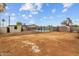 A spacious dirt backyard featuring a building, a black chain-link fence surrounding the pool, and a shed at 5519 W Campbell Ave, Phoenix, AZ 85031