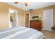 Bedroom featuring a ceiling fan, dresser with television, and access to a bathroom at 5519 W Campbell Ave, Phoenix, AZ 85031