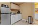 Kitchenette with wood-look vinyl floors, stainless steel fridge, stainless steel trash can, and wooden cabinets at 5519 W Campbell Ave, Phoenix, AZ 85031