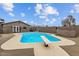 Backyard pool with diving board surrounded by concrete patio and a gray house behind a black fence at 5519 W Campbell Ave, Phoenix, AZ 85031