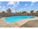 Large in-ground pool surrounded by a concrete patio and a brick fence and blue skies at 5519 W Campbell Ave, Phoenix, AZ 85031