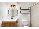 Updated bathroom with modern vanity, round mirror, open shelving, and glass shower at 5809 E Thomas Rd, Scottsdale, AZ 85251