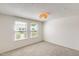 Bright bedroom with neutral carpet, two windows, and a modern wicker light fixture at 5809 E Thomas Rd, Scottsdale, AZ 85251