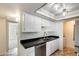 Compact kitchen with white cabinets, stainless steel appliances, and neutral tile floor at 5809 E Thomas Rd, Scottsdale, AZ 85251