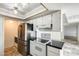 Compact kitchen with white cabinets, stainless steel appliances, and neutral tile floor at 5809 E Thomas Rd, Scottsdale, AZ 85251