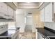 Compact kitchen with white cabinets, stainless steel appliances, and neutral tile floor at 5809 E Thomas Rd, Scottsdale, AZ 85251