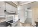 Compact kitchen with white cabinets, stainless steel appliances, and neutral tile floor at 5809 E Thomas Rd, Scottsdale, AZ 85251
