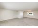 Spacious living room showcasing neutral carpet, white walls and a modern light fixture at 5809 E Thomas Rd, Scottsdale, AZ 85251