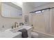 Bright bathroom featuring marble countertop, gold fixtures, and bathtub with shower at 6432 S 23Rd Ave, Phoenix, AZ 85041