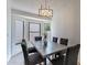 Dining room with large windows, gray chairs, and a modern chandelier at 6432 S 23Rd Ave, Phoenix, AZ 85041