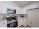 Updated kitchen with stainless steel appliances, white cabinets, and tiled backsplash at 6432 S 23Rd Ave, Phoenix, AZ 85041