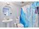 Cozy bathroom featuring a pedestal sink, commode, and shower with blue patterned shower curtain at 6626 N Majorca E Way, Phoenix, AZ 85016