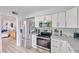 Bright kitchen featuring stainless steel appliances, white cabinets and views into the living room at 6626 N Majorca E Way, Phoenix, AZ 85016