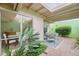 Enclosed patio with seating area and lush landscaping seen through a living room window at 6626 N Majorca E Way, Phoenix, AZ 85016