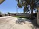 Large backyard with concrete patio, artificial turf, and decorative stone areas under a generous shade tree at 6823 W Garfield St, Phoenix, AZ 85043