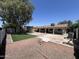 Expansive backyard featuring artificial turf, gravel landscaping, and a concrete patio under a large tree at 6823 W Garfield St, Phoenix, AZ 85043
