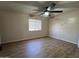 Bedroom with wood laminate floors, a ceiling fan, and a window with blinds for natural light at 6823 W Garfield St, Phoenix, AZ 85043