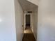 Hallway with wood look tile floors and white walls, equipped with storage closets and lighting fixtures at 6823 W Garfield St, Phoenix, AZ 85043