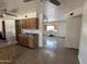 Open kitchen with tile floors and vintage wood cabinetry, leading into an additional space at 6823 W Garfield St, Phoenix, AZ 85043