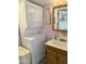Functional bathroom featuring a stacked washer and dryer unit next to a vanity and mirror at 7750 E Broadway Rd # 123, Mesa, AZ 85208