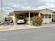 View of a manufactured home exterior featuring a covered parking area and desert landscaping at 7750 E Broadway Rd # 123, Mesa, AZ 85208