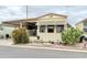 A manufactured home exterior featuring beige siding, awning, and desert landscaping at 7750 E Broadway Rd # 123, Mesa, AZ 85208