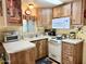 Traditional-style kitchen featuring oak cabinets, white appliances and countertops, and a double basin sink at 7750 E Broadway Rd # 123, Mesa, AZ 85208