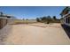 Oversized dirt backyard with a partial block wall, offering ample space for outdoor activities and gardening at 812 E Piute Ave, Phoenix, AZ 85024