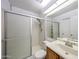 Bathroom features a white tiled shower with sliding glass doors and a vanity with sink at 812 E Piute Ave, Phoenix, AZ 85024