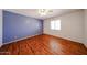 Cozy bedroom features wood floors, blue accent wall, and a bright window at 812 E Piute Ave, Phoenix, AZ 85024