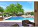 Stunning pool with a large, green tree centered in the landscape design at 8230 E Via Del Sol Dr, Scottsdale, AZ 85255