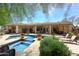 A luxurious pool and spa are surrounded by a stone patio in this desert oasis at 8230 E Via Del Sol Dr, Scottsdale, AZ 85255