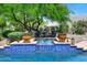 Inviting pool featuring a cascading water feature, lush greenery, and comfortable seating at 8230 E Via Del Sol Dr, Scottsdale, AZ 85255