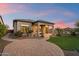 Beautiful backyard featuring a covered patio, green lawn, and mature landscaping at sunset at 8234 E Inca St, Mesa, AZ 85207