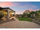 Spacious backyard with stone paver patio, manicured lawn, covered porch, and desert landscaping at 8234 E Inca St, Mesa, AZ 85207