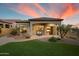 Charming backyard with manicured lawn, covered patio, desert landscaping, and outdoor seating area at 8234 E Inca St, Mesa, AZ 85207
