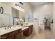 Bathroom featuring double sinks, tiled floors, dark wood cabinets, and a large vanity mirror at 8234 E Inca St, Mesa, AZ 85207