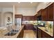 Open kitchen with stainless appliances, tiled backsplash, granite counters, and dark wood cabinets at 8234 E Inca St, Mesa, AZ 85207