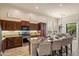 A spacious kitchen features dark wood cabinetry, stainless steel appliances, and a large granite island with bar seating at 8234 E Inca St, Mesa, AZ 85207